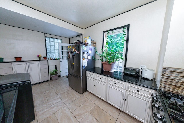 8521 80th St, Woodhaven, NY 11421 - kitchen with freestanding refrigerator, gas range, dark countertops, decorative backsplash, and white cabinetry