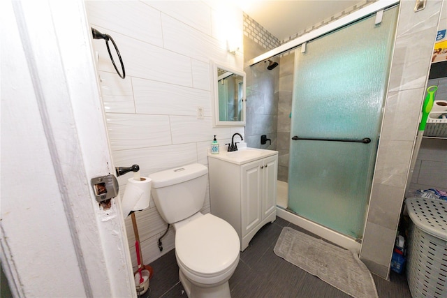 8521 80th St, Woodhaven, NY 11421 - bathroom with tile walls, a shower stall, toilet, vanity, and tile patterned floors