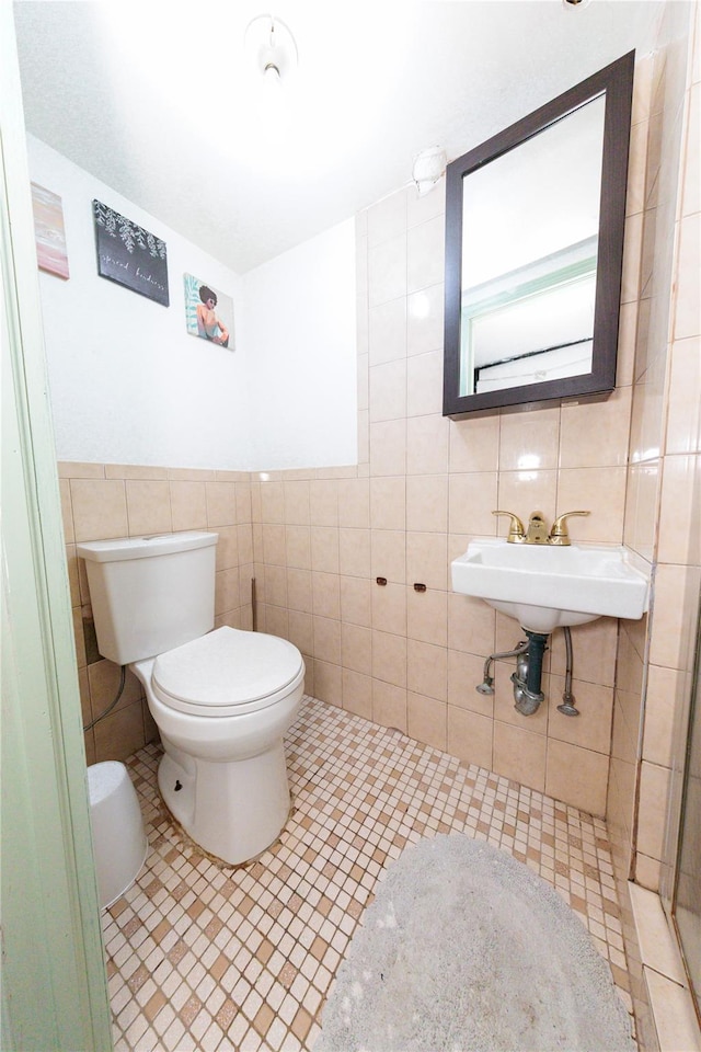 8521 80th St, Woodhaven, NY 11421 - bathroom with tile walls, toilet, tile patterned floors, and a sink