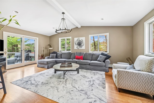 living area featuring a baseboard radiator, lofted ceiling with beams, light wood-type flooring, and a notable chandelier