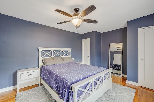 bedroom with wood finished floors, a ceiling fan, and baseboards