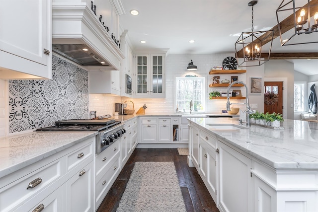 kitchen featuring custom range hood, a sink, plenty of natural light, white cabinets, and recessed lighting