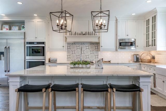 kitchen with built in appliances, a chandelier, white cabinets, decorative light fixtures, and recessed lighting