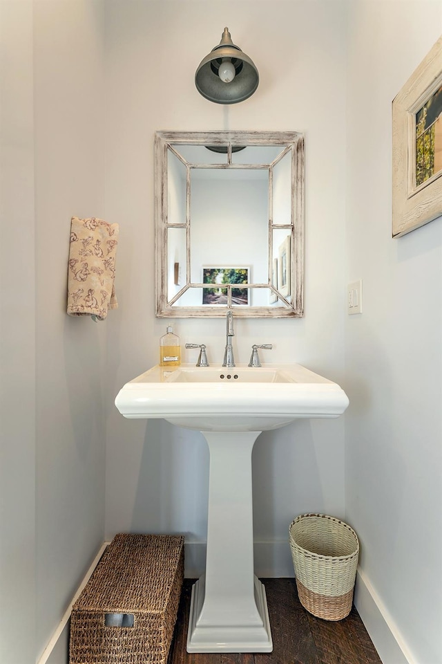 bathroom with baseboards, a sink, and wood finished floors