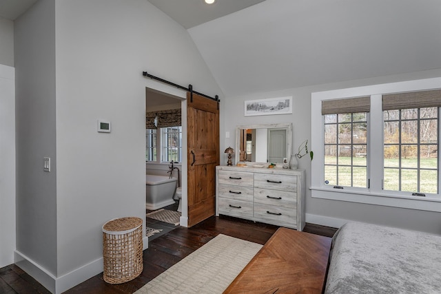 bedroom with a barn door, baseboards, dark wood finished floors, and high vaulted ceiling