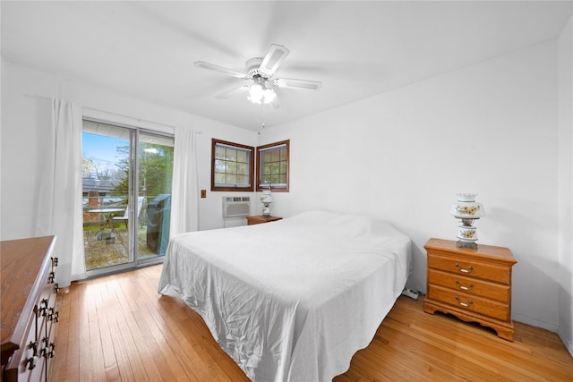 bedroom with a ceiling fan, light wood-style floors, a wall unit AC, and access to exterior