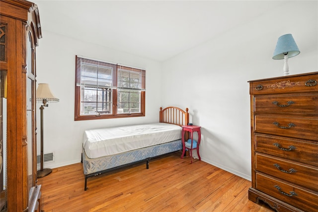 bedroom with light wood finished floors, baseboards, and visible vents