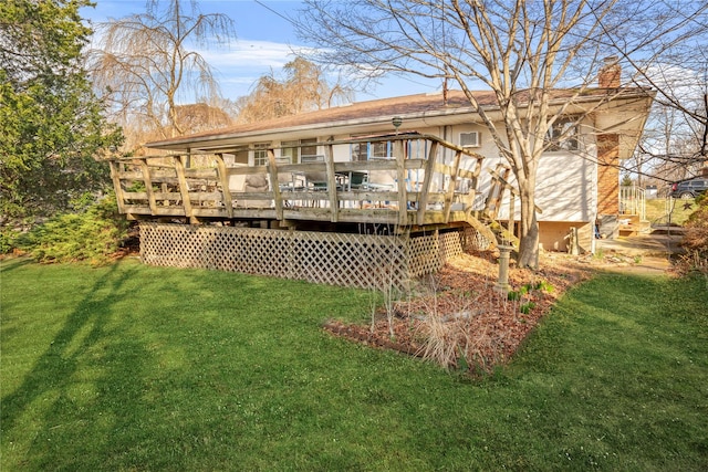 rear view of house with stairs, a chimney, a yard, and a deck