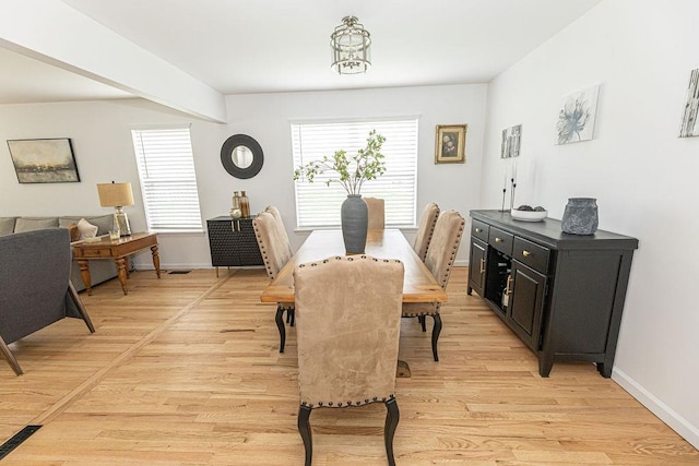 dining space featuring light wood-style flooring and baseboards