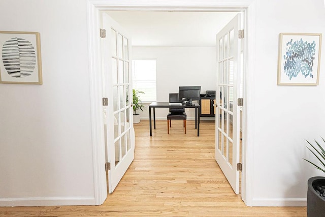 office area with french doors, baseboards, and light wood-style flooring