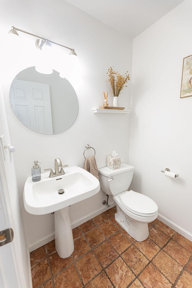 half bathroom featuring toilet and baseboards