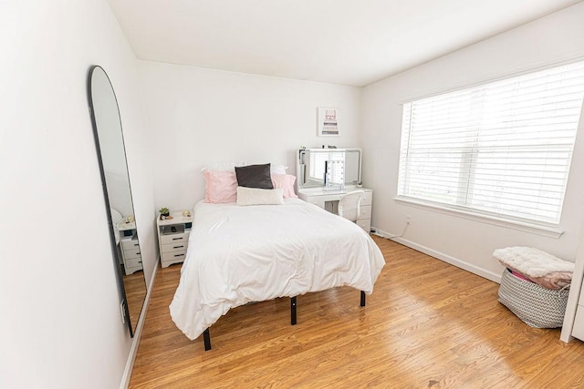 bedroom featuring light wood-style floors and baseboards
