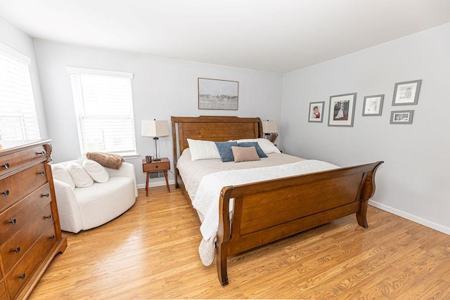 bedroom with baseboards and light wood finished floors