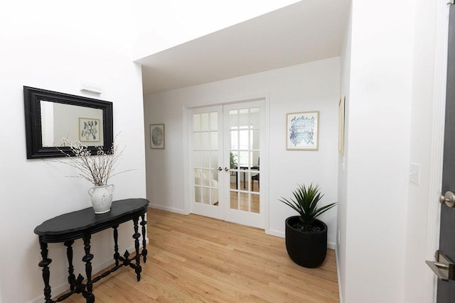 entryway with light wood-style floors, baseboards, and french doors