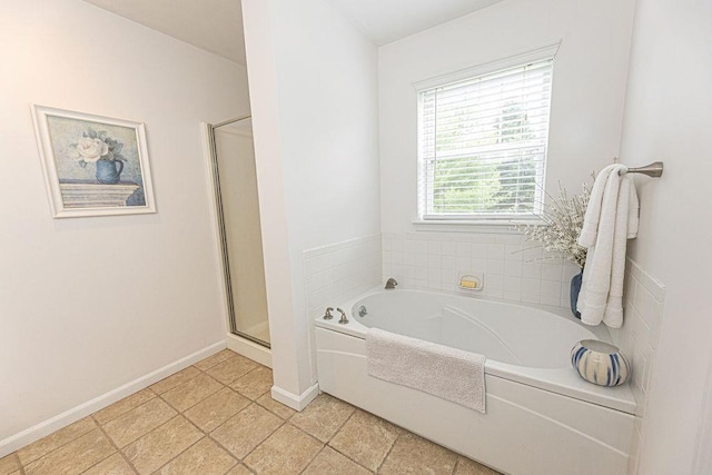 full bathroom with a shower stall, a garden tub, and baseboards