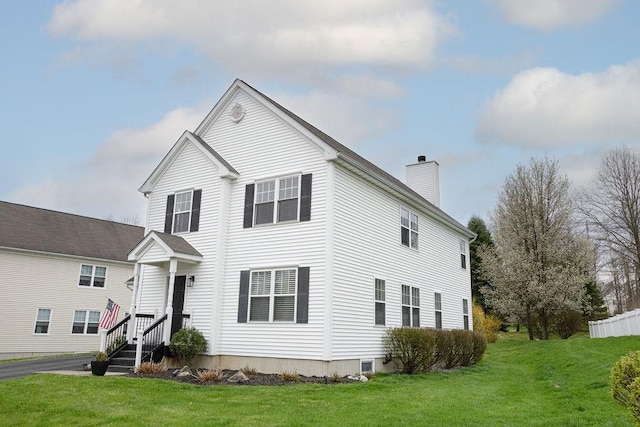 traditional-style house featuring a front yard and a chimney