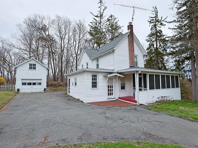 4073 Rte 9w, Saugerties, NY 12477 - view of front of house featuring a sunroom, a garage, an outbuilding, driveway, and a chimney