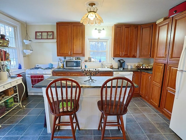 4073 Rte 9w, Saugerties, NY 12477 - kitchen with a breakfast bar area, brown cabinets, dark countertops, a kitchen island, and white appliances