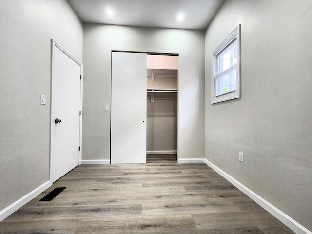24 Wayne St, Staten Island, NY 10310 - unfurnished bedroom featuring wood finished floors, baseboards, and a closet