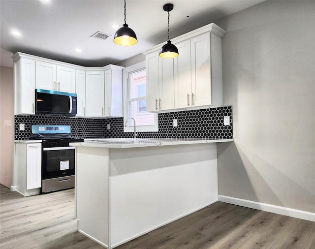 24 Wayne St, Staten Island, NY 10310 - kitchen featuring appliances with stainless steel finishes, wood finished floors, white cabinets, and recessed lighting