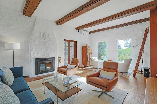 living room with a fireplace, light wood-style floors, a wall mounted air conditioner, french doors, and beamed ceiling