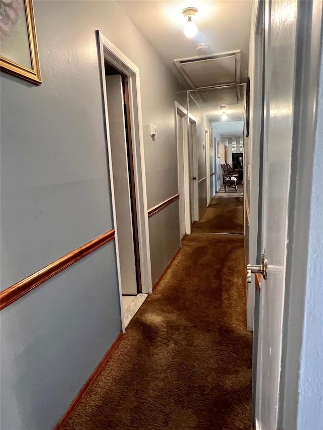 corridor featuring attic access and carpet flooring