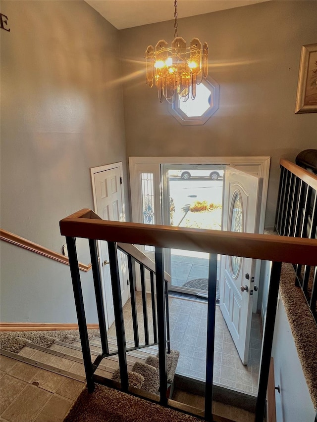 foyer entrance with baseboards, a notable chandelier, and stairway
