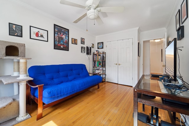 living area featuring crown molding, light wood finished floors, and ceiling fan