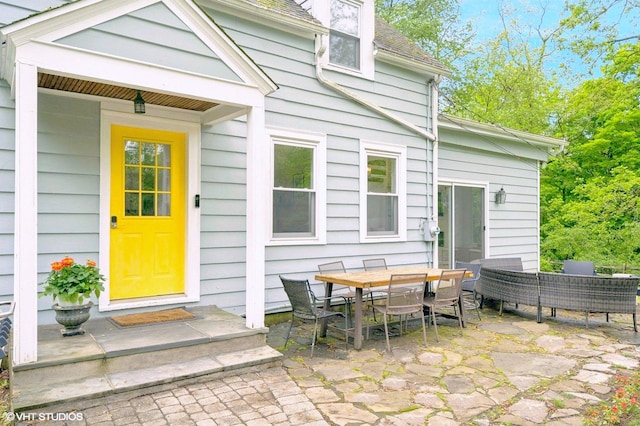 893 Laroe Rd, Monroe, NY 10950 - view of exterior entry featuring a patio, roof with shingles, and outdoor dining space