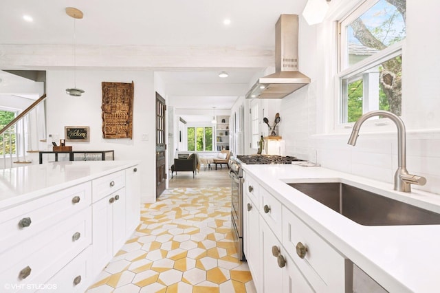 893 Laroe Rd, Monroe, NY 10950 - kitchen with stainless steel gas range, island exhaust hood, a sink, light countertops, and decorative light fixtures