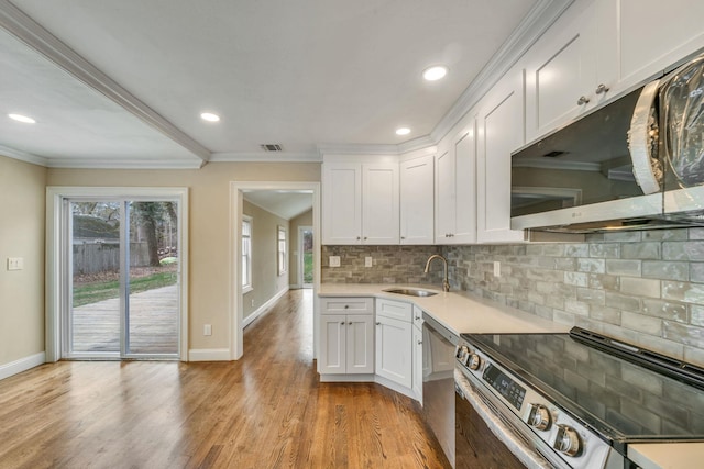 kitchen featuring white cabinets, baseboards, stainless steel appliances, and a sink