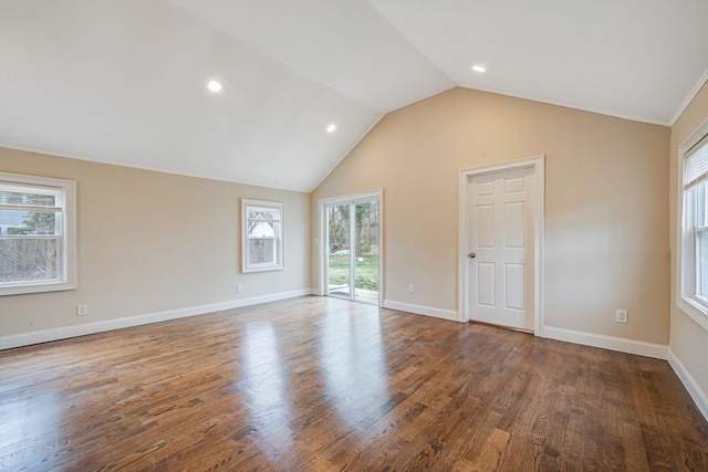 unfurnished room featuring vaulted ceiling, wood finished floors, and a wealth of natural light