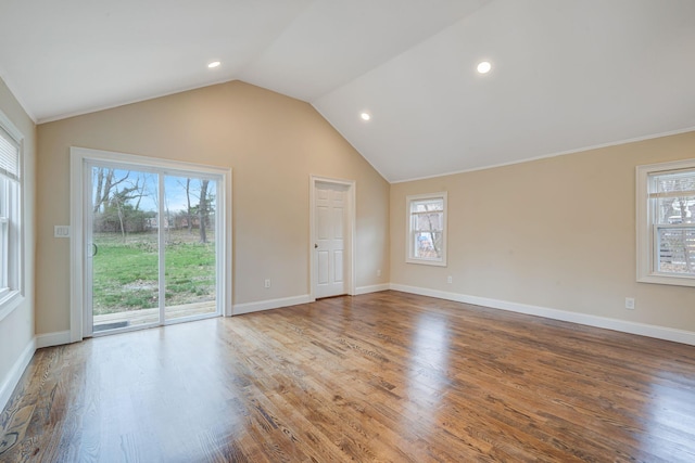 unfurnished living room with lofted ceiling, plenty of natural light, and wood finished floors