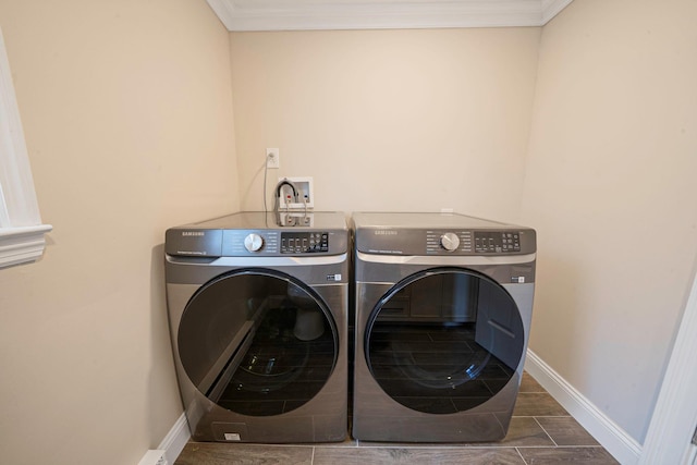 washroom featuring baseboards, washer and clothes dryer, laundry area, and ornamental molding