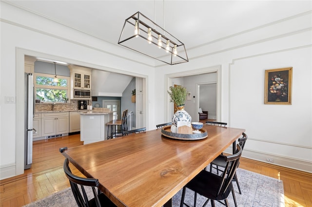 dining room with baseboards and light wood-type flooring