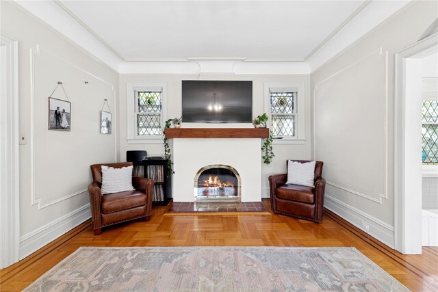 sitting room with baseboards, a fireplace with flush hearth, and a healthy amount of sunlight