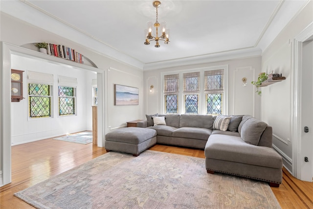 living area with an inviting chandelier, plenty of natural light, and wood finished floors