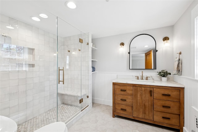 full bath featuring vanity, recessed lighting, wainscoting, and a stall shower