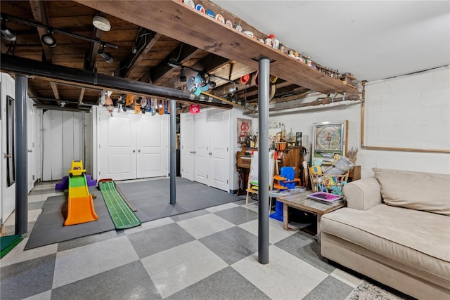 unfinished basement featuring tile patterned floors and concrete block wall