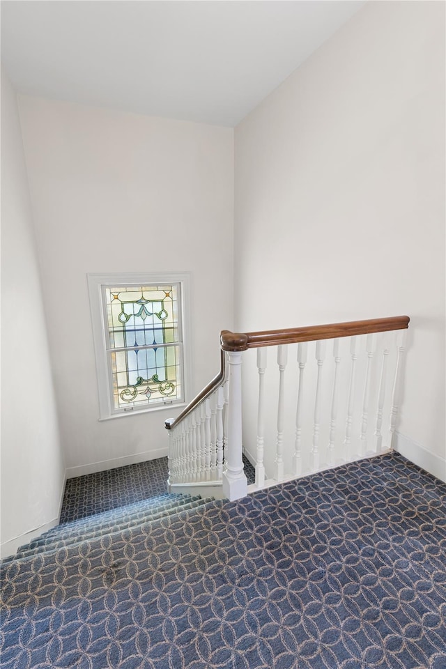 staircase featuring carpet floors and baseboards