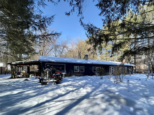 snow covered house featuring a chimney