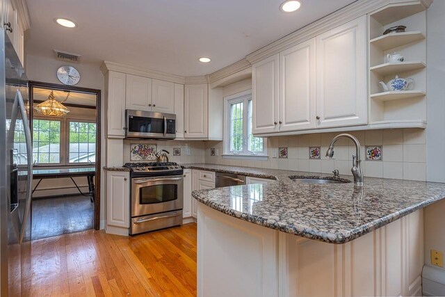 26 Strathmore Dr, New City, NY 10956 - kitchen featuring a peninsula, white cabinets, a sink, light wood-style flooring, and appliances with stainless steel finishes