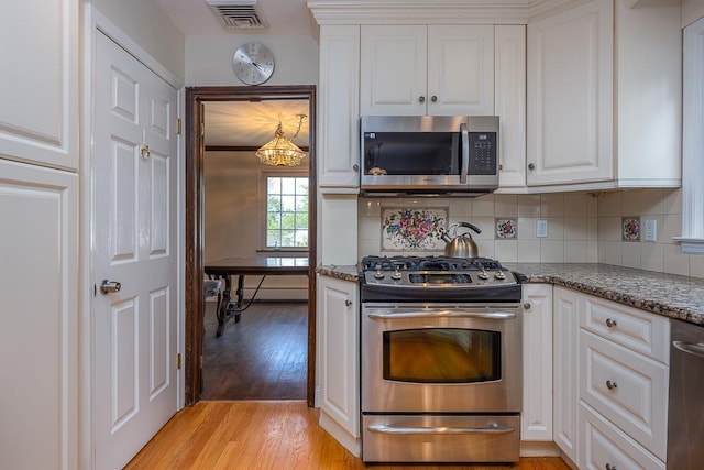 26 Strathmore Dr, New City, NY 10956 - kitchen with light wood-style floors, appliances with stainless steel finishes, white cabinetry, and visible vents