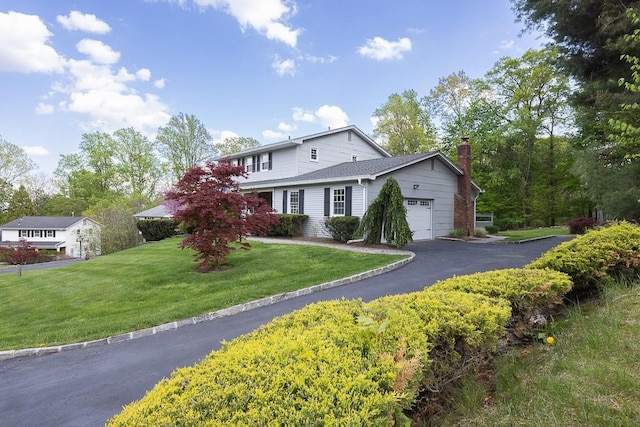26 Strathmore Dr, New City, NY 10956 - traditional-style home with an attached garage, a chimney, driveway, and a front lawn