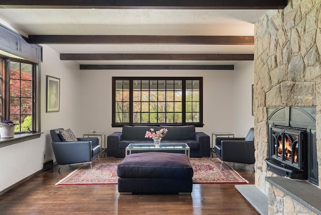 living area with beam ceiling, wood finished floors, baseboards, and a fireplace