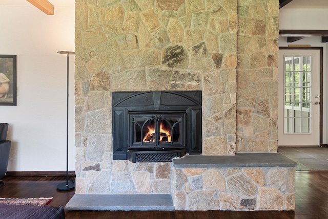 interior details with baseboards, a stone fireplace, and wood finished floors