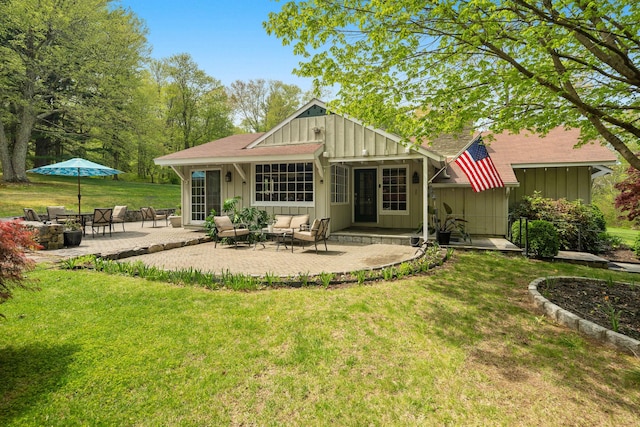 back of property featuring a shingled roof, board and batten siding, a yard, and a patio