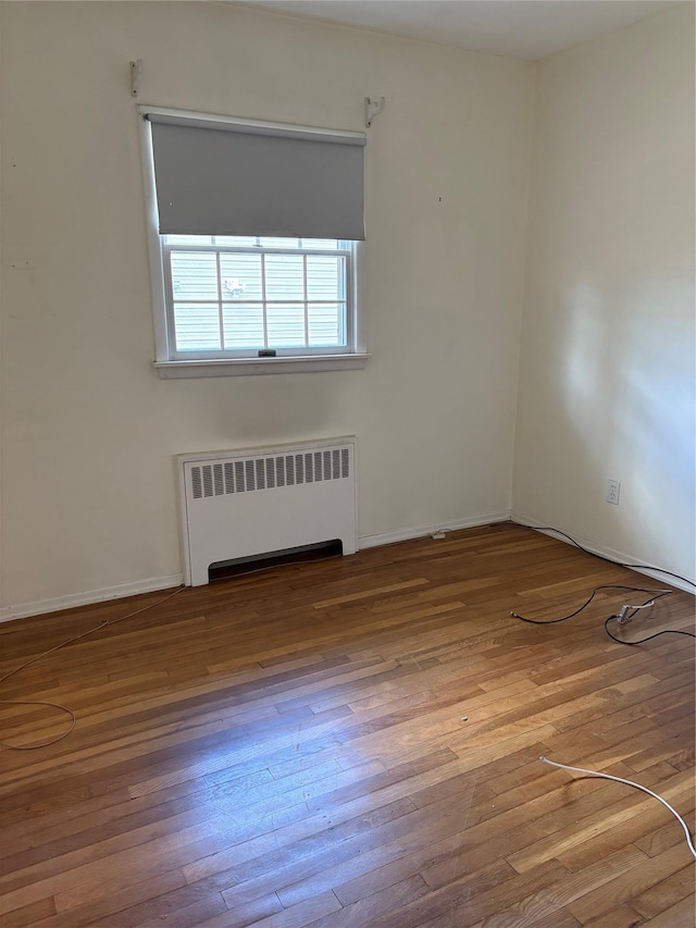 8 Dee Pl, Huntington Station, NY 11746 - unfurnished room featuring wood-type flooring, radiator heating unit, and baseboards