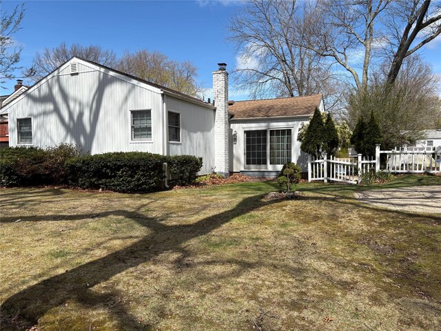 8 Dee Pl, Huntington Station, NY 11746 - rear view of house featuring a chimney and a lawn