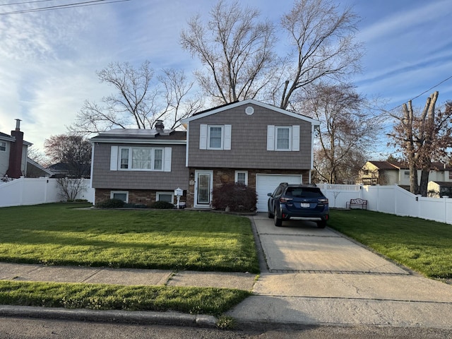 split level home with fence, driveway, a front yard, and a garage